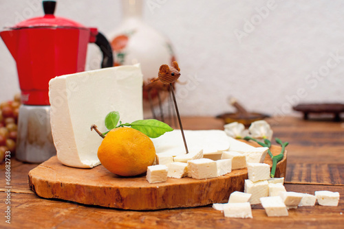 Toma de una tabla de madera con queso fresco partido en cubos y a la mitad exquisito manjar  photo