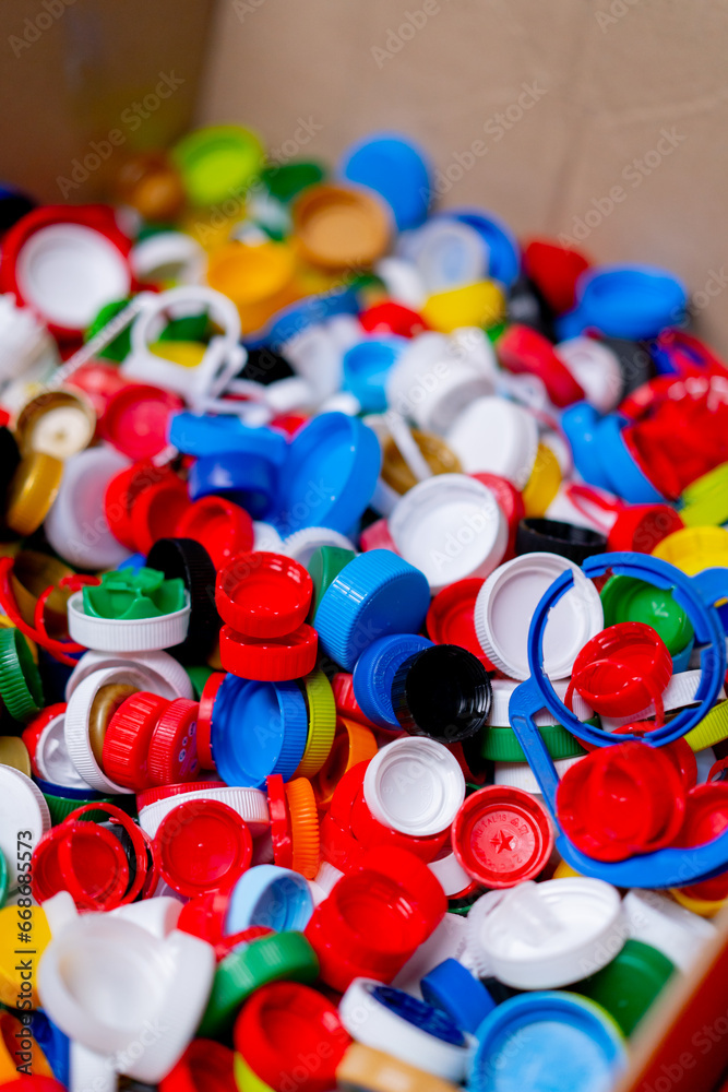 Close-up shot of multi-colored caps from used bottles stored at recycling and waste disposal sorting station