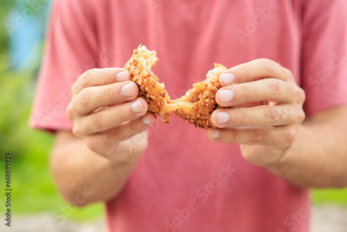 A guy's hand holds sweet pastry with jam, snack and fast food concept. Selective focus on hands with blurred background photo