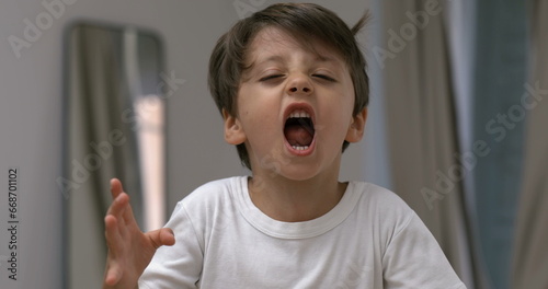 Foto Angry child yelling and screaming at camera in super slow-motion