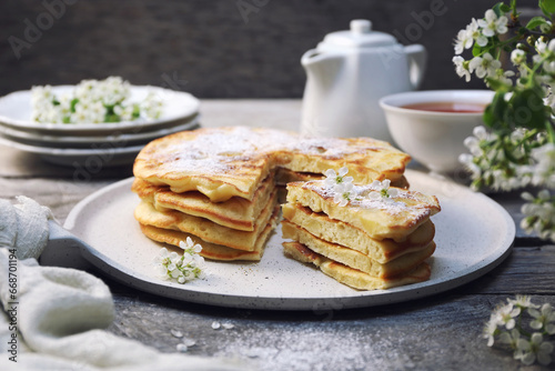 French cuisine. Matefaim. Stack of sweet Apple Pancakes  cup of tea and white spring flowers