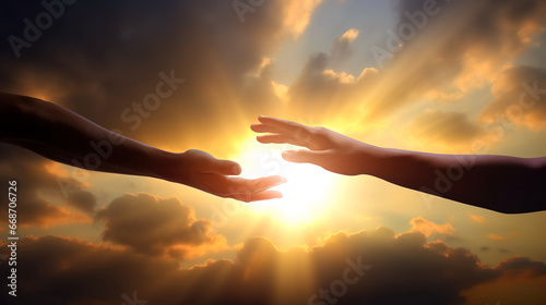 Hand reaching out for help in front of bright sunset sky  photo