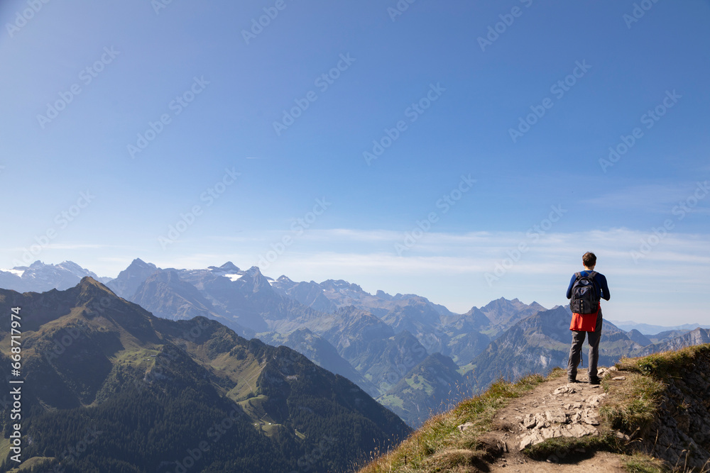 Hiker in the mountains taking pictures of the view, Stoos, Schwyz, Switzerland
