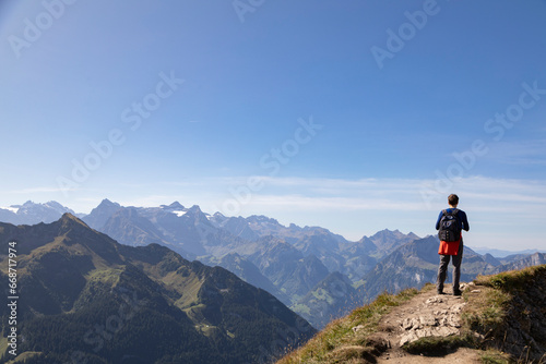 Hiker in the mountains taking pictures of the view, Stoos, Schwyz, Switzerland 