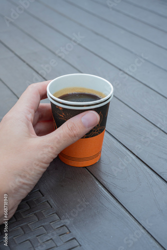 Female hand with paper cup and selective focus. photo