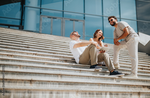 Focused young business team discussing new projects and analyzing statistics outdoors in a city area. Creative entrepreneurs strategize for success and profitable outcomes.