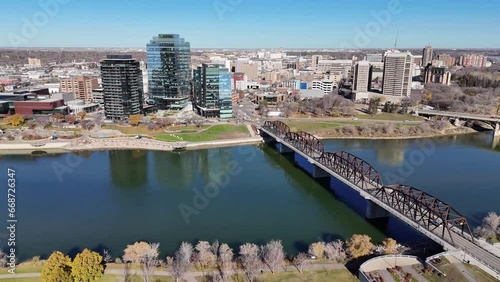 Aerial video of Saskatoon's downtown central business district, SK, Canada. Skyline view reveals bustling urban life, commercial buildings, and roads. Ideal for business concepts.