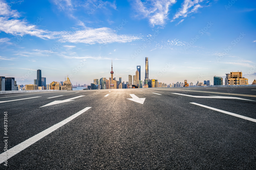 Asphalt road and city buildings skyline background in Shanghai