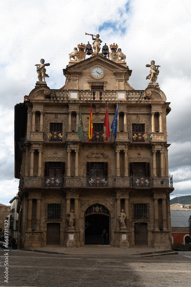 Obraz premium Vista del ayuntamiento de Pamplona, su fachada y su balcón, donde se lanza el chupinazo de las fiestas de San Fermin con las banderas oficiales.