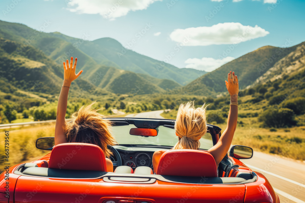 Two girls in red car driving with their hands up. Freedom concept and traveling escape. - obrazy, fototapety, plakaty 