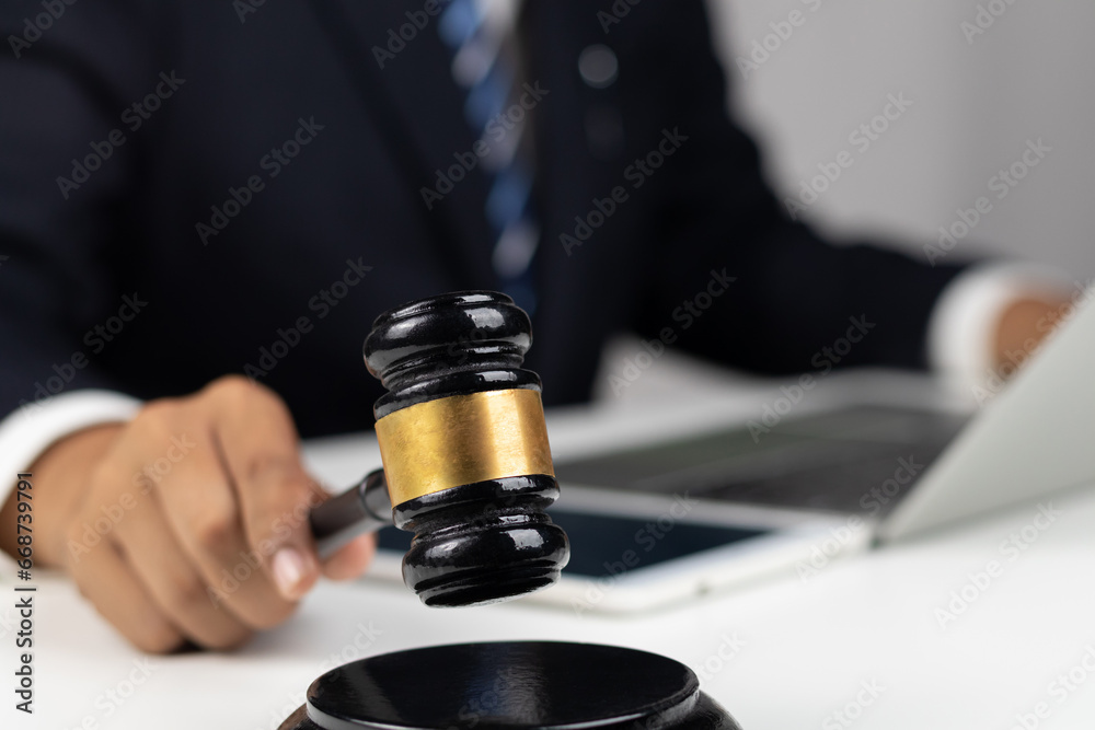 Justice, Law, Attorney and Court judge concept. Man judge hand holding gavel to bang on sounding block in the court room. Professional lawyer considering with contract papers in courtroom.