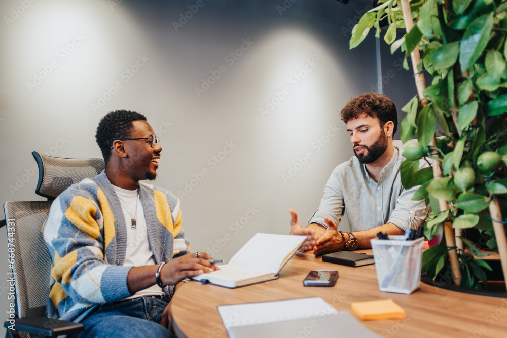 Diverse colleagues collaborate on a new project in a co working space. They tackle tasks, solve problems, and search for profit growth together in a small company's office.