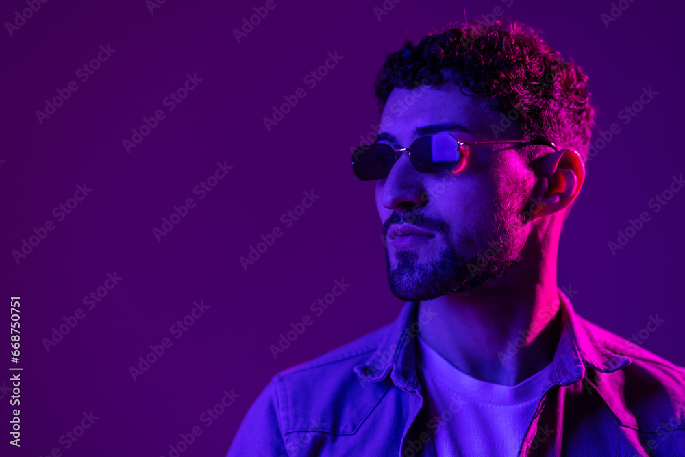 Neon light portrait of serious man beard in sunglasses Neon light portrait of serious man beard in sunglasses