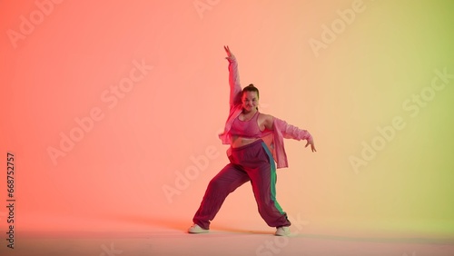 Photography Attractive woman dancing jazz-funk on red and green neon background in a studio