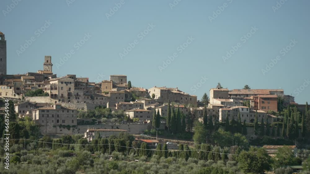 View of San Gimignano surrounded by cypress trees and vineyards in Tuscan landscape, San Gimignano, Tuscany, Italy View of San Gimignano surrounded by cypress trees and vineyards in Tuscan landscape, San Gimignano, Tuscany, Italy