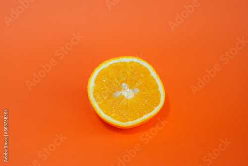 Cut open orange with orange background.