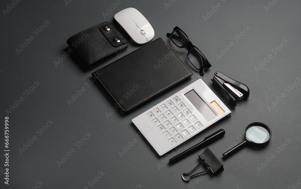 Notebook and stationery on dark gray background. Business concept. Creative layout.
