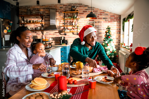 A joyful African American family shares a festive breakfast on Christmas morning