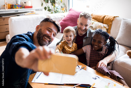 Gay couple capturing a cherished moment with their children during art time photo