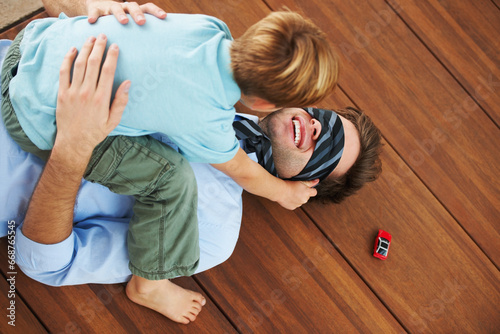 Man, blindfold and playing with child in living room, happy and family home with support of businessman with kid. Man, boy and quality time together with trust in fantasy, game and care on floor