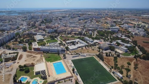 Drone video footage over the Portuguese city of Faro over a sports complex, stadium and university.