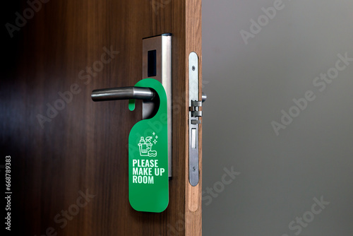 Please make up room. Sign hanging on doorknob. Hotel tag for bedroom door.