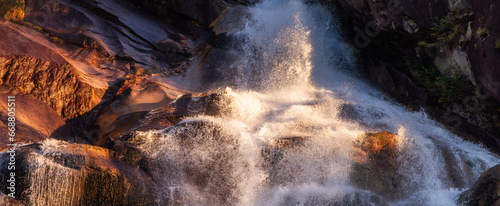 Waterfall rushing down the rocks. Sunset. Shannon Falls, Squamish, BC, Canada.