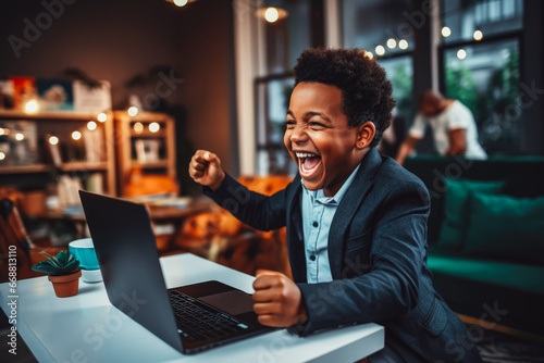 Beautiful young black man smiling and rejoicing after success. Happy man celebrating business success on sofa in living room with computer.