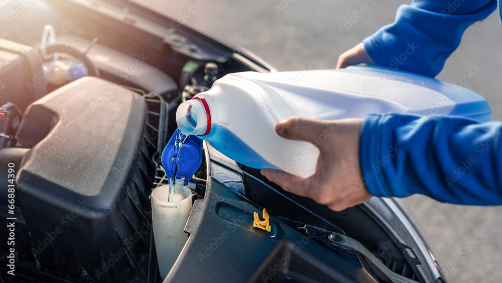 Pouring antifreeze. Filling a windshield washer tank with an antifreeze.