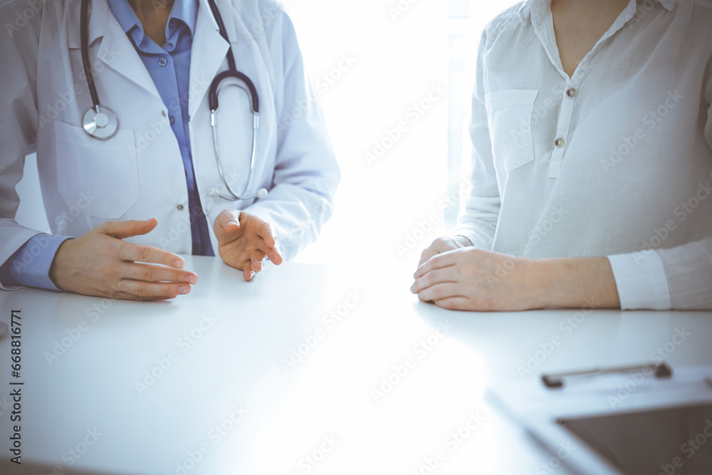Doctor and patient discussing current health questions while sitting near of each other at the table in clinic, just hands closeup. Medicine concept Doctor and patient discussing current health questions while sitting near of each other at the table in clinic, just hands closeup. Medicine concept