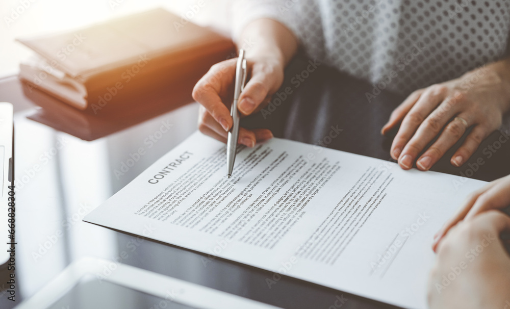 Business people sitting and discussing contract in office, closeup. Partners or lawyers working together at meeting. Teamwork and partnership Business people sitting and discussing contract in office, closeup. Partners or lawyers working together at meeting. Teamwork and partnership