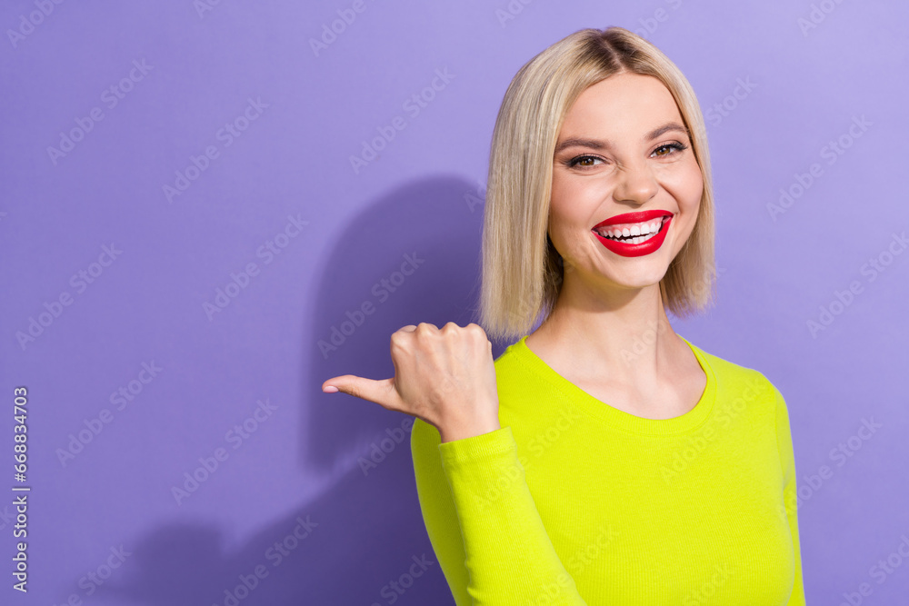 Photo of toothy beaming woman with bob hairstyle dressed yellow clothes directing empty space promo isolated on purple color background Photo of toothy beaming woman with bob hairstyle dressed yellow clothes directing empty space promo isolated on purple color background