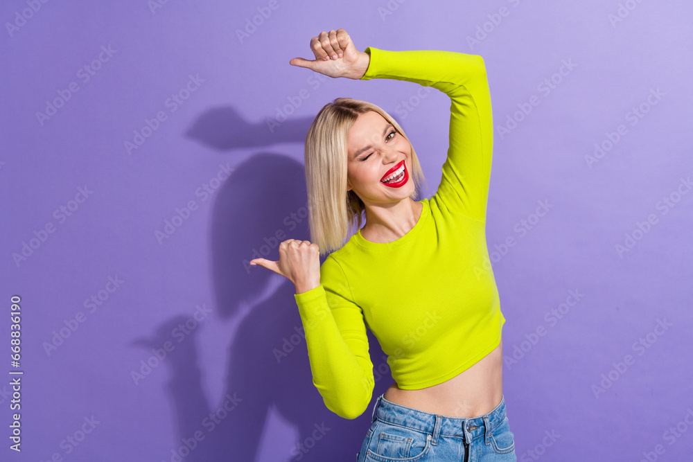 Photo of pretty woman with bob hairstyle dressed yellow clothes winking directing at offer empty space isolated on purple color background Photo of pretty woman with bob hairstyle dressed yellow clothes winking directing at offer empty space isolated on purple color background