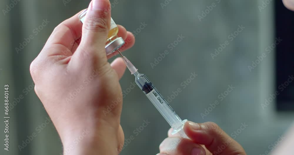 Using syringe suck out of bottle by turning the medicine bottle upside down and slowly pulling the medicine out of the bottle.Syringe with liquid being drawn into syringe.