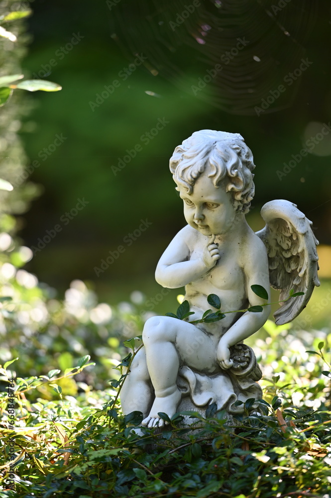 A small, white sandstone sculpture of an angel on a cemetery in Weimar-Germany. A small, white sandstone sculpture of an angel on a cemetery in Weimar-Germany.