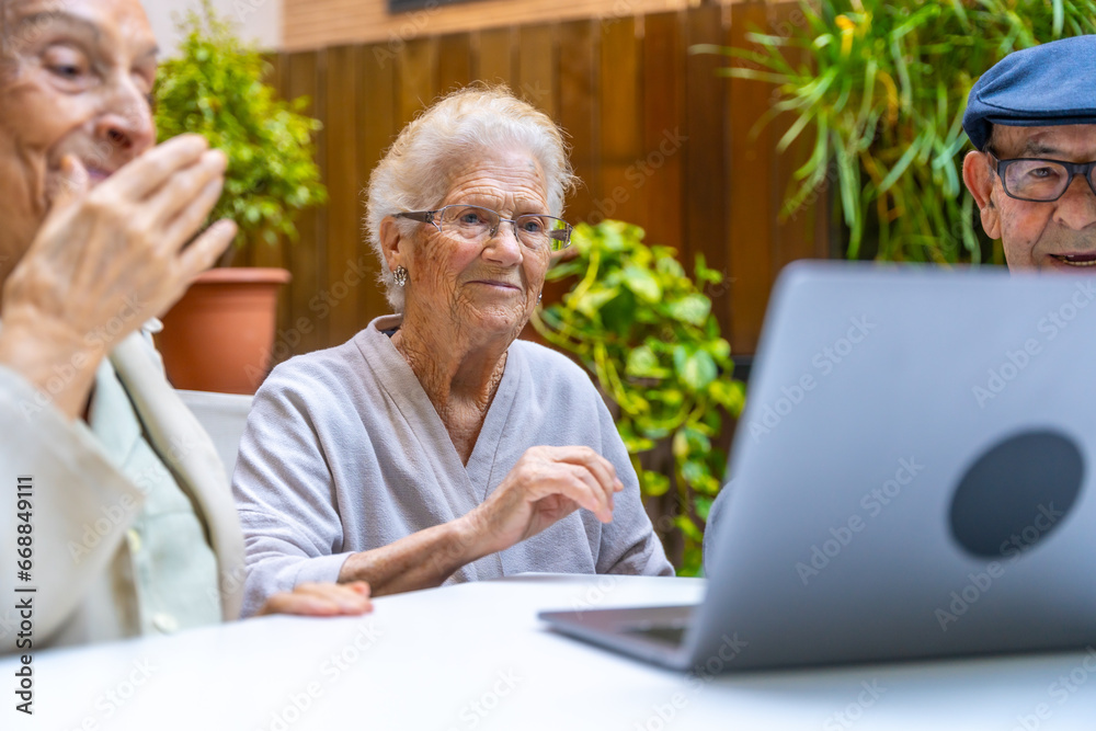 Seniors learning how to use a laptop in a geriatric Seniors learning how to use a laptop in a geriatric