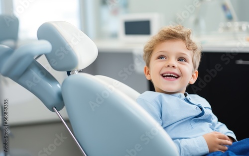 A happy child sitting in the dental chair at a dentist photo