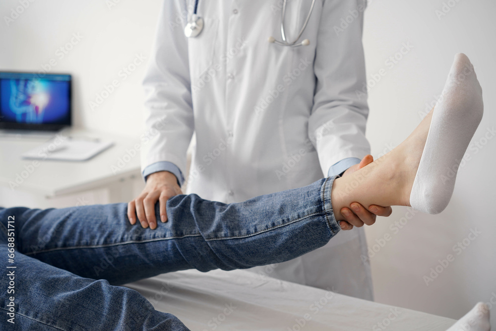Doctor and patient are at the usual medical inspection in the clinic. Therapist examines a young woman's knee. Medicine concept