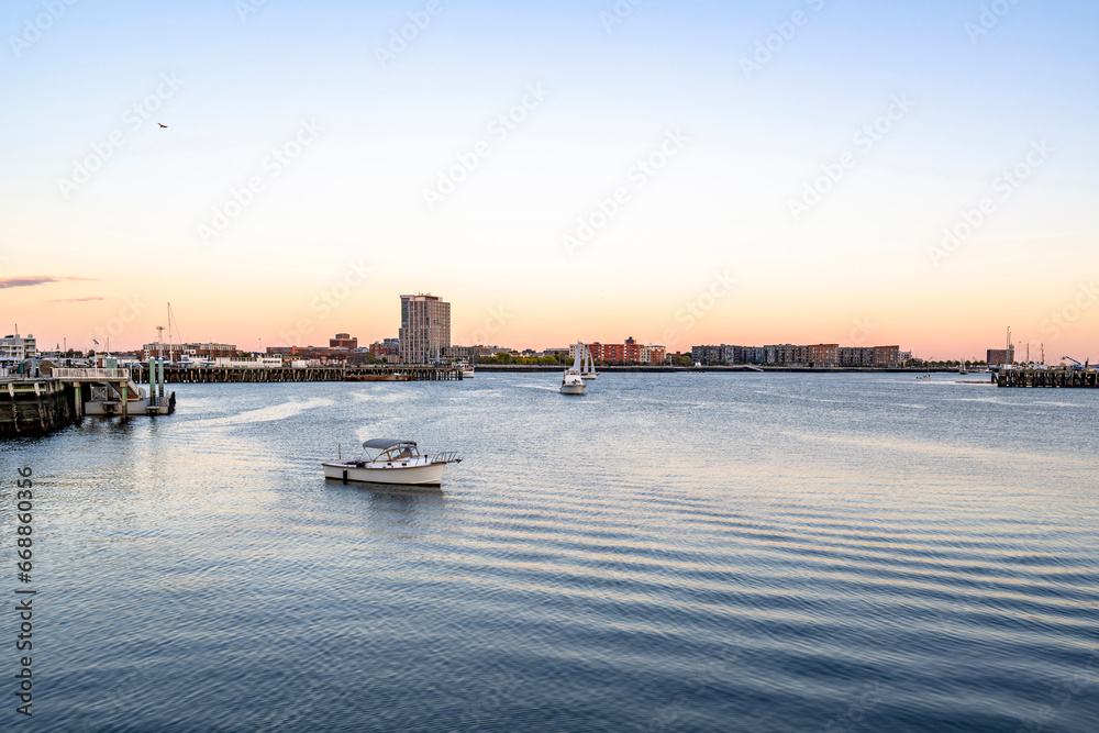 Yachts and boats on the water in the bay of the Atlantic Ocean with a network of wooden moorings in Boston in New England
