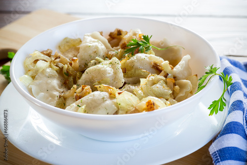 Ukrainian Vareniky or Pierogi stuffed with potato and mushrooms, served with fried onion.