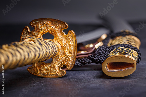 Japanese samurai katana sword and scabbard close up. Photo of a weapon in low key with selective focus