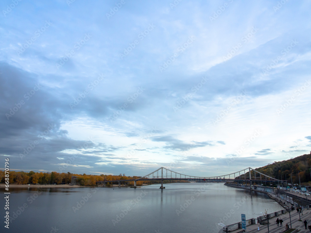 View of the Dnipro River and yellow trees in the center of the city. Historical architecture and landscape, nature of Kyiv. The city center of Kyiv, Ukraine in autumn. Beautiful sky.