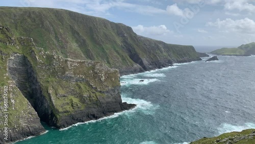 Scenic view of famous Kerry cliffs (Aillte Chiarrai) and Puffin island. Irish coastal nature. Motion of big Atlantic ocean waves. Kerry Cliffs viewpoint, Kerry, Ireland photo