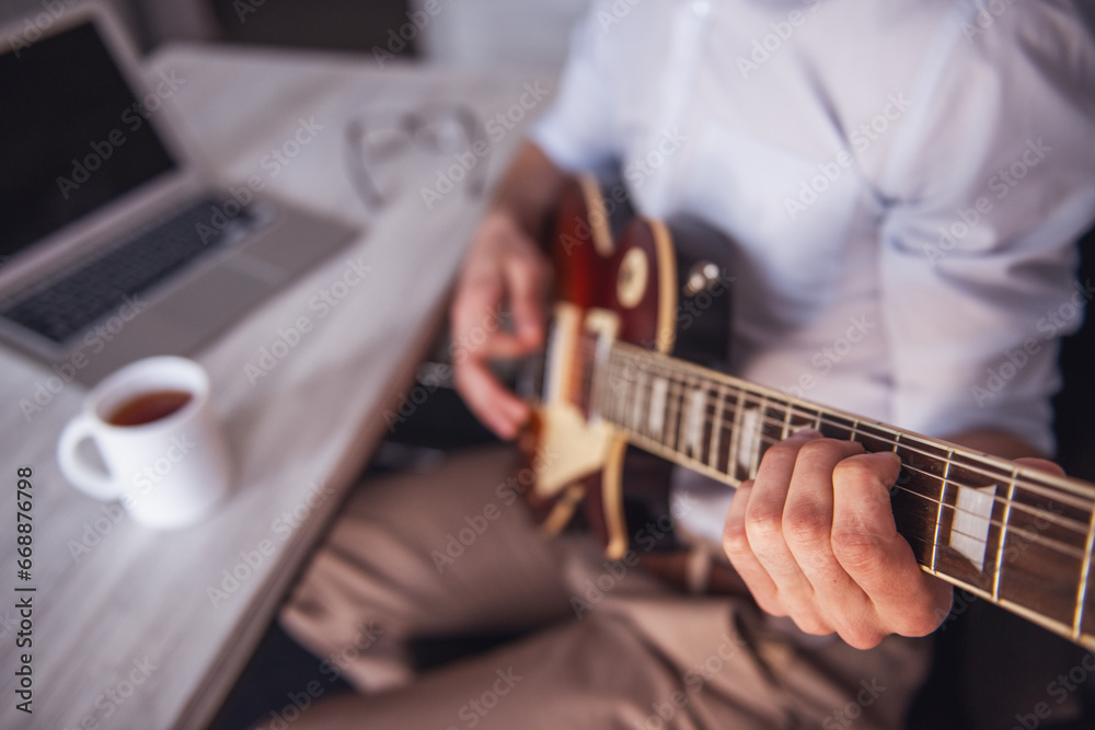 Handsome businessman playing guitar