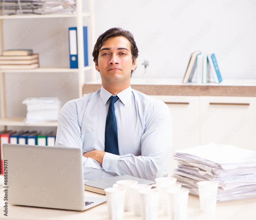 Young employee addicted to coffee Young employee addicted to coffee
