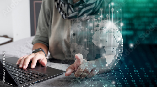Mujer trabajando en su laptop desde su casa, aprovechando la tecnología, adaptada a un mundo globalizado. Globo terráqueo rodeado de ceros y unos. Su dedo toca el mundo digital.