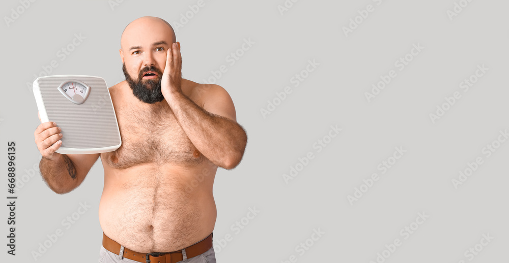 Fototapeta premium Overweight man holding scales on grey background with space for text. Weight loss concept