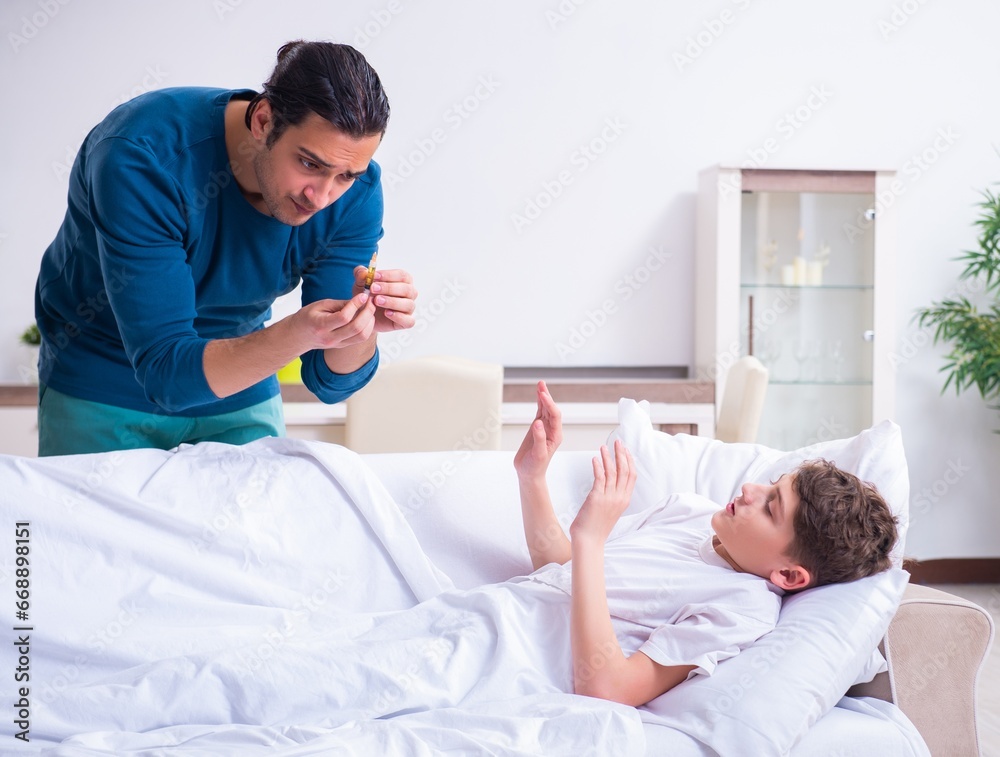 Fototapeta premium Young father caring for sick son