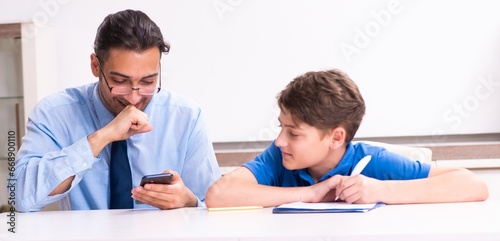 Busy father helping his son to prepare for exam