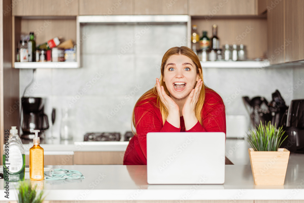 Portrait of excited beautiful woman, freelancer using laptop, remote job from home in kitchen Portrait of excited beautiful woman, freelancer using laptop, remote job from home in kitchen